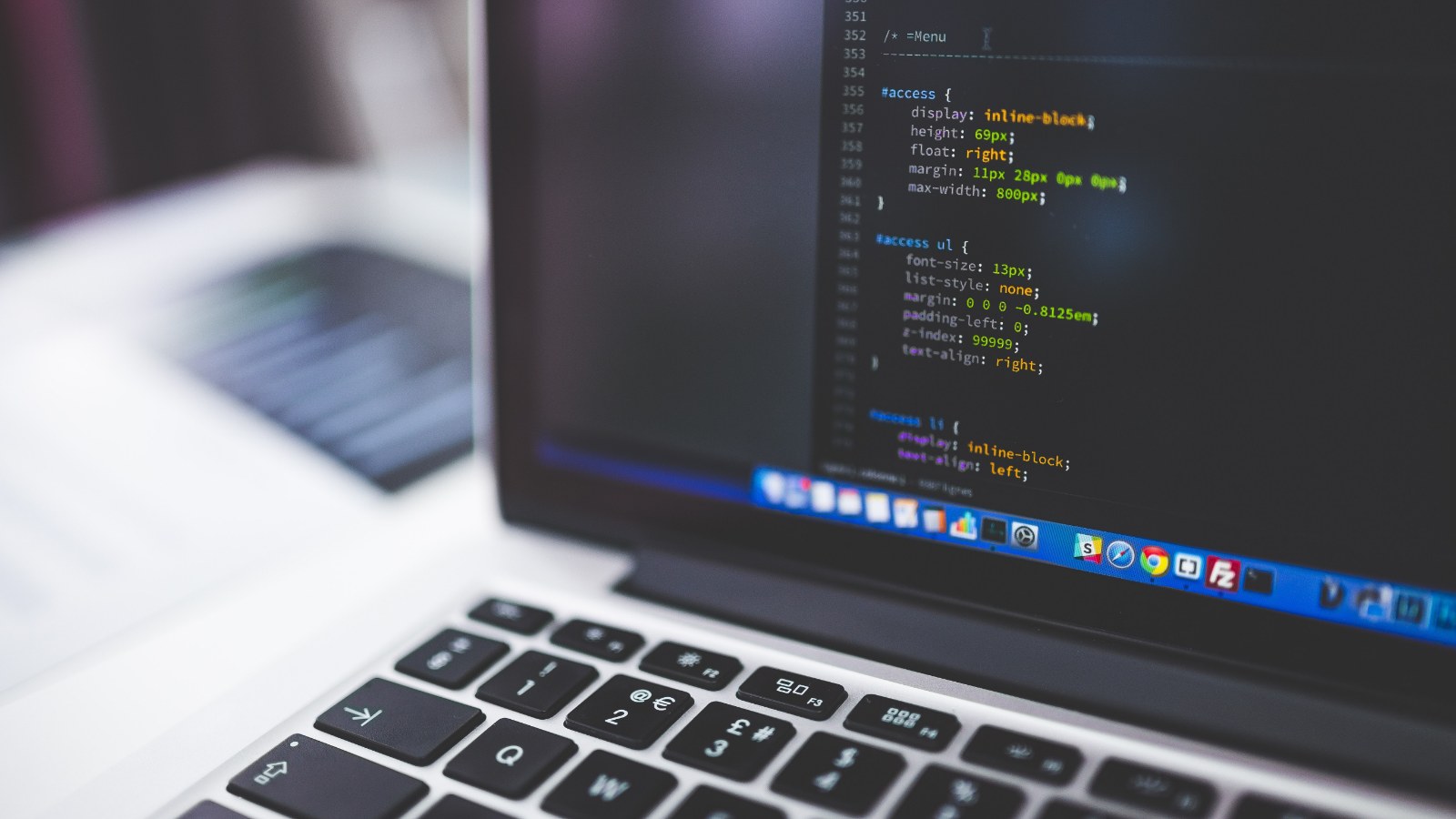 A laptop screen showing lines of code.