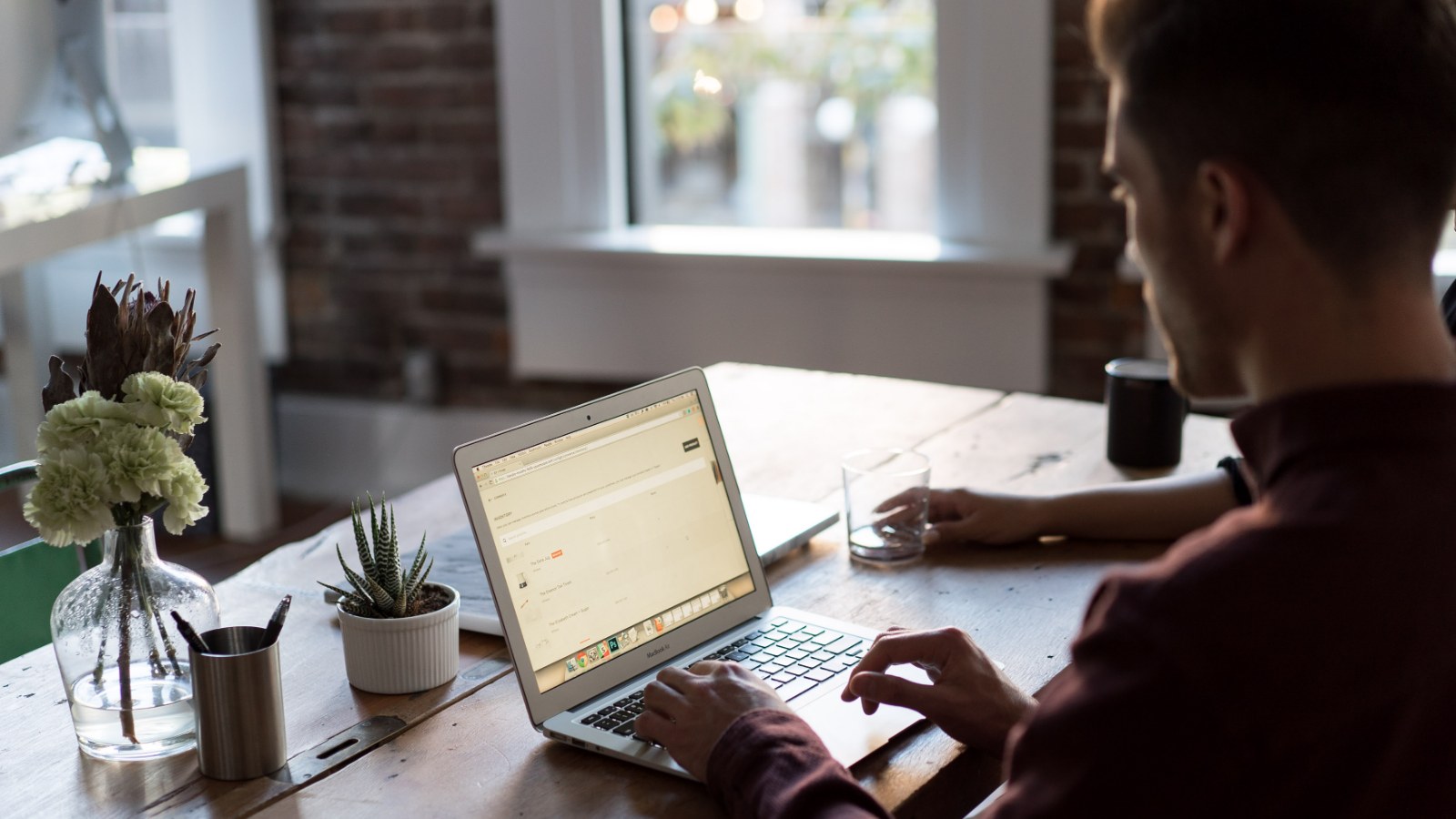A person working at a laptop inside an office.