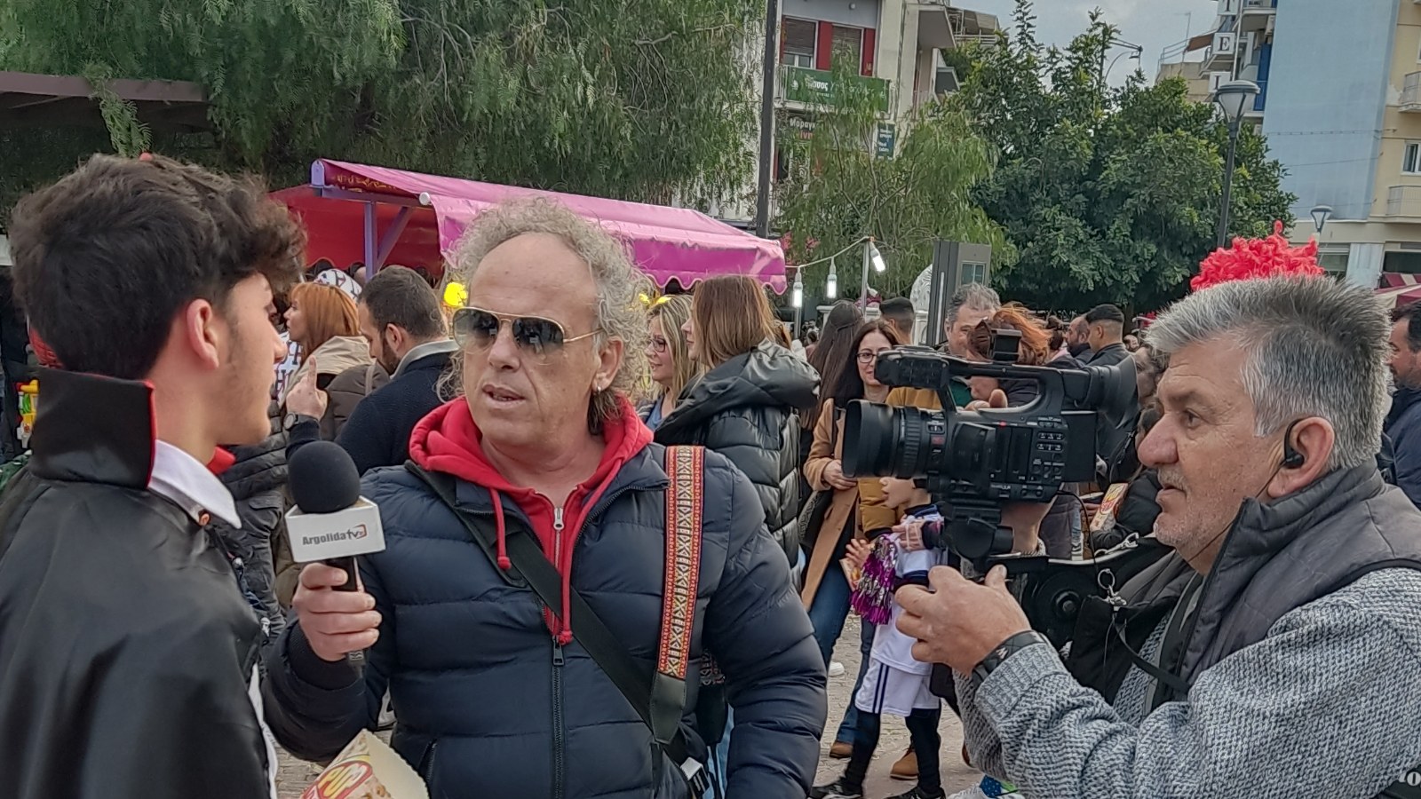 A local journalist interviewing a person outdoors.